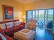 Relax in this living room with balcony access, water view, comfortable seating, and warm lighting at 6401 99Th N Way # 15C, St Petersburg, FL 33708