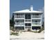 Three story beach house with white balconies overlooking beach at 712 Beach Trl # C, Indian Rocks Beach, FL 33785