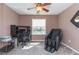 Relax in this room with a dark gray massage chair, ceiling fan, and picturesque window overlooking the lake at 7352 Cutwater Ln, Wesley Chapel, FL 33545