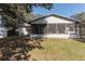 A spacious backyard with a screen porch, storage shed, and partially shady areas at 8436 Cameo St, Spring Hill, FL 34608