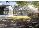 A fenced backyard features a screen porch, pool enclosure, mature trees, and grass at 8436 Cameo St, Spring Hill, FL 34608