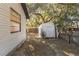 A view of the backyard with a window, storage shed, and a wooden fence at 8436 Cameo St, Spring Hill, FL 34608