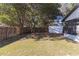 A fenced backyard features grass, mature trees, and a white storage shed at 8436 Cameo St, Spring Hill, FL 34608