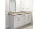 Updated bathroom features white cabinets, double sinks, granite counters, and modern fixtures at 8436 Cameo St, Spring Hill, FL 34608