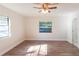 Sun-drenched bedroom showcasing wood-look floors, two windows and a ceiling fan at 8436 Cameo St, Spring Hill, FL 34608