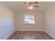 Bright bedroom featuring wood-look floors, a window with a neighborhood view, and a ceiling fan at 8436 Cameo St, Spring Hill, FL 34608