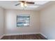 Cozy bedroom with wood-look floors, a ceiling fan, and a window overlooking the pool at 8436 Cameo St, Spring Hill, FL 34608