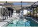 In-ground screened pool offers privacy and relaxation in a fenced-in backyard with mature trees at 8436 Cameo St, Spring Hill, FL 34608