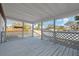 Covered back porch featuring tongue and groove ceiling and decorative railing at 9403 W Perio Pl, Tampa, FL 33612