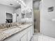 Bathroom with granite counter tops, dual sinks, a walk in shower and a large mirror at 14 Seagrape Cir, Clearwater, FL 33759