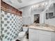 Bathroom featuring granite counters, modern vanity, and patterned shower curtain at 14 Seagrape Cir, Clearwater, FL 33759