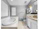 Bathroom boasts a garden tub, granite counters, and window with bright light at 14 Seagrape Cir, Clearwater, FL 33759
