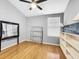 Bedroom with wood floors, blank shelves, ceiling fan, and large mirror at 14 Seagrape Cir, Clearwater, FL 33759