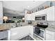 Modern kitchen features stainless steel appliances, granite counters, and white cabinets at 14 Seagrape Cir, Clearwater, FL 33759
