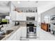 Well-lit kitchen features white cabinetry, granite countertops, and stainless steel appliances at 14 Seagrape Cir, Clearwater, FL 33759