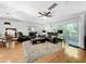Bright and open living room with hardwood floors, a large area rug, and comfortable reclining sofas at 14 Seagrape Cir, Clearwater, FL 33759