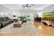 Spacious living room with hardwood floors, a large area rug, comfortable seating, and a mounted television at 14 Seagrape Cir, Clearwater, FL 33759