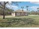 Charming single-story home with a 2-car garage, well-manicured lawn, complemented by beautiful palm trees and blue skies at 11145 Mountain Mockingbird Rd, Weeki Wachee, FL 34614