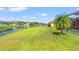 Scenic backyard view overlooking a serene pond and lush green space, with mature trees and a screened lanai at 12524 25Th E Ct, Parrish, FL 34219