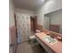 Vintage pink bathroom with tiled walls, sink, mirror, toilet and shower/tub combo at 1564 S Michigan Ave, Clearwater, FL 33756