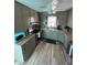 A gray kitchen with wooden-look tile flooring, stone countertops, and stainless steel appliances at 1564 S Michigan Ave, Clearwater, FL 33756