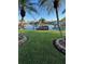 Landscaped waterfront backyard featuring dock and palm trees at 16103 4Th E St, Redington Beach, FL 33708