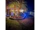 Night view of landscaped backyard featuring palm trees, ambient lighting, and lush green lawn at 16103 4Th E St, Redington Beach, FL 33708