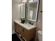 Modern bathroom vanity with double sinks, elegant fixtures, and sleek lighted mirrors at 16103 4Th E St, Redington Beach, FL 33708