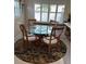 Elegant dining area featuring a glass-top table, wooden chairs, and a patterned rug, bathed in natural light at 16103 4Th E St, Redington Beach, FL 33708