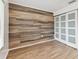 This bedroom features wood flooring, an accent wall, and sliding closet doors at 211 Somerset Cirle N, Dunedin, FL 34698