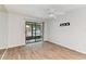 The bedroom showcases light wood flooring, a sliding glass door, and a ceiling fan at 211 Somerset Cirle N, Dunedin, FL 34698