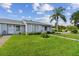 A cozy single-story home with lush green grass and manicured landscaping that adds to its curb appeal at 211 Somerset Cirle N, Dunedin, FL 34698