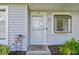 Close-up of the inviting front entrance featuring a welcome mat and charming decor at 211 Somerset Cirle N, Dunedin, FL 34698