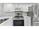 Stylish kitchen featuring white cabinets, stainless steel appliances, and modern finishes at 211 Somerset Cirle N, Dunedin, FL 34698