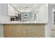 Modern kitchen showcasing a breakfast bar with stone accents and updated stainless appliances at 211 Somerset Cirle N, Dunedin, FL 34698