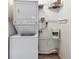 A stacked washer and dryer next to wire racks for storage at 211 Somerset Cirle N, Dunedin, FL 34698