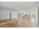 Bright living room with ample space, wood-look flooring, and a view into the updated kitchen at 211 Somerset Cirle N, Dunedin, FL 34698