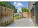View of a concrete patio with a wooden fence and a glimpse of the neighborhood beyond at 211 Somerset Cirle N, Dunedin, FL 34698