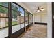 This light-filled sunroom features tile flooring, windows, and a ceiling fan at 211 Somerset Cirle N, Dunedin, FL 34698
