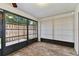 Enclosed sunroom featuring wood-look tile, bright windows and a ceiling fan at 211 Somerset Cirle N, Dunedin, FL 34698