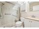 Bright bathroom featuring a glass enclosed shower, white vanity, and a granite countertop at 2400 Franciscan Dr # 34, Clearwater, FL 33763
