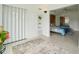 Bright bedroom with built-in shelving, neutral tile floors and a large bed behind a folding door at 2400 Franciscan Dr # 34, Clearwater, FL 33763