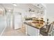 Bright kitchen featuring white cabinetry, stainless steel appliances, and a charming breakfast bar at 2400 Franciscan Dr # 34, Clearwater, FL 33763
