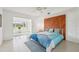 Spacious main bedroom features tile floors, wood accent wall, and ample natural light from the adjacent sunroom at 2400 Franciscan Dr # 34, Clearwater, FL 33763