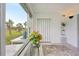 Sunroom with views of palm trees and lush green lawn, featuring a decorative plant and tiled floors at 2400 Franciscan Dr # 34, Clearwater, FL 33763