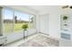 Sunroom featuring expansive windows overlooking the golf course, storage shelves, and tiled floors at 2400 Franciscan Dr # 34, Clearwater, FL 33763
