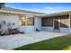 Relaxing back patio area perfect for outdoor entertaining, featuring a screened door and a well-kept lawn at 2630 Pinewood Dr, Dunedin, FL 34698