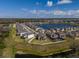 A captivating aerial view of a community bordering a tranquil lake with houses with private pools at 3150 Marine Grass Dr, Wimauma, FL 33598