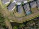 Aerial view highlights a spacious backyard with pond access, complemented by a private swimming pool at 3150 Marine Grass Dr, Wimauma, FL 33598