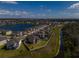 Overhead shot of a sprawling neighborhood near a creek, complemented by lush green spaces at 3150 Marine Grass Dr, Wimauma, FL 33598
